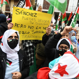 Varias personas, con banderas saharauis y una pancarta que reza 'Sánchez, puedes vender tu dignidad pero no la del pueblo saharaui', protestan durante una manifestación convocada por la Coordinadora Estatal de Asociaciones Solidarias con el Sáhara (CEA