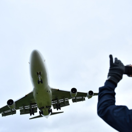 Un hombre fotografía con su teléfono a un avión. (REUTERS/Dylan Martínez)