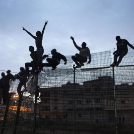 Inmigrantes intentan saltar la valla de Melilla. Archivo REUTERS (2014)