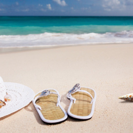  Un sombrero y unas sandalias en una playa. PIXABAY