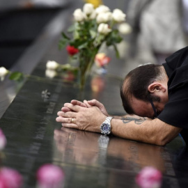 El neoyorquino Rocco diNardo reza ante el monumento a las víctimas del 11-S en el Memorial del 11-S en Nueva York (Estados Unidos). JUSTIN LANE | EFE