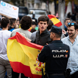 Varios jóvenes conversan con un agente de Policía durante una manifestación contra la amnistía, frente a la sede del PSOE. EUROPA PRESS/Diego Radamés