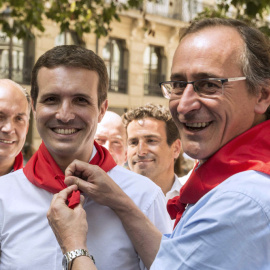 El presidente del PP del País Vasco, Alfonso Alonso, pone al presidente de los populares, Pablo Casado, el pañuelo festivo durante la visita de ésta a Vitoria. EFE