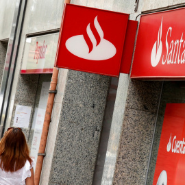 Una mujer pasa por delante de sendas sucursales de Banco Santander y Banco Popular en Barcelona. REUTERS/Albert Gea