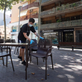 30/07/2020.- Un camarero prepara las mesas de un restaurante del centro de Gavà (Barcelona), una de las poblaciones, junto a Castelldefels, en las que el Govern ha ampliado las restricciones que afectan a Barcelona por el aumento de contagios de covid-19