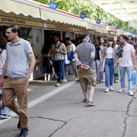 Varias personas caminan entre las casetas de la Feria del Libro de Madrid, este miércoles en el Parque del Retiro. EFE/ J P Gandul