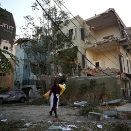 Una mujer caminando por los restos de la explosión en Beirut. / REUTERS