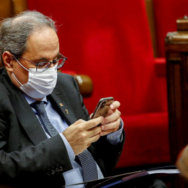 El presidente de la Generalitat, Quim Torra, consulta su dispositivo móvil durante el debate de política general que anualmente celebra el Parlament. /EFE