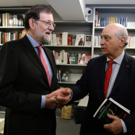 10/10/2019.- El expresidente del Gobierno Mariano Rajoy (i) conversa con el exministro del Interior Jorge Fernández Díaz (d) durante la presentación de su libro "Cada día tiene su afán". / EFE - JAVIER LIZÓN