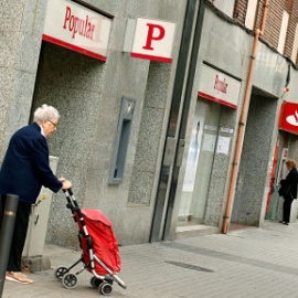 Una mujer pasa junto a una sucursal del Banco Popular en Barcelona. REUTERS/ Albert Gea