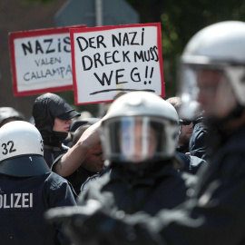 Manifestantes sostienen carteles para protestar contra una manifestación extremistas en Hamburgo. AFP / CHRISTIAN CHARISIUS