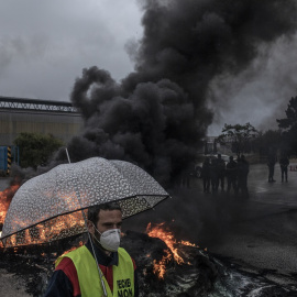 Un trabajador de Alcoa frente a una barricada en la entrada de la factoría de Alcoa custodiada por la Guardia Civil en San Cibrao, Lugo. MANU BRABO