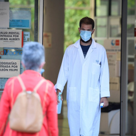 Un sanitario recibe a una paciente termómetro en mano en el centro de salud Federica Montseny en el distrito de Puente de Vallecas en Madrid.-EFE