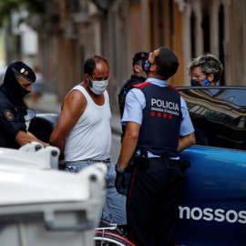 Mossos d'esquadra custodian a uno de los detenidos en la operación contra el terrorismo yihadista que llevan a cabo desde primera hora de la mañana en el distrito de Ciutat Vella de Barcelona. EFE/Toni Albir