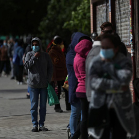 Personas haciendo cola en la calle para recibir alimentos, como ayuda de una asociación vecinal en Madrid. REUTERS/Susana Vera