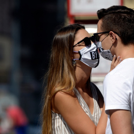 Una pareja con mascarilla mientras se besan. Europa Press / Archivo