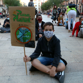 Manifestant amb una pancarta reivindicativa en la protesta organitzada a Tarragona per denunciar l'emergència climàtica. ACN/Mar Rovira