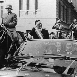 El presidente de Chile, Salvador Allende, saluda a sus seguidores desde su coche descubierto, en Santiago, pocas semanas después de su elección. A su lado, a caballo, es escoltado por el general Augusto Pinochet. AFP