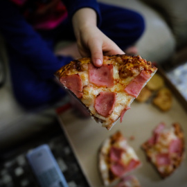 Un niño de la Comunidad de Madrid comiendo Telepizza a través de los servicios contratados por el Gobierno regional para las familias  perceptoras de Renta Mínima de Inserción (RMI) durante el confinamiento. / EUROPA PRESS