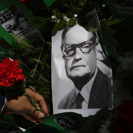 Un hombre deja una flor sobre la imagen del presidente chileno Salvador Allende, este viernes en Santiago. Chile conmemora el 47 aniversario del golpe de Estado de Augusto Pinochet, que derrocó al Gobierno de Salvador Allende, en plena pandemia de corona