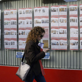 Una joven pasa por delante de una inmobiliaria con anuncios de casas en alquiler o en venta en el centro de Madrid. REUTERS/Andrea Comas