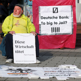 Un manifestante protesta en el exterior de la junta de accionistas de Deutsche Bank, en Fráncfort, con un cartel que dice "Esta economía mata. El Papa Francisco". REUTERS / Kai Pfaffenbach