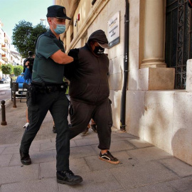 Un agente de la Guardia Civil traslada al Juzgado de Instrucción número 1 de Ontinyent, en Valencia, a uno de los detenidos por su supuesta participación en una violación grupal a una menor de 14 años en la localidad valenciana de l'Olleria que se pr