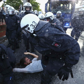 Varios agentes antidisturbios cargan contra un manifestante en Hamburgo. /REUTERS