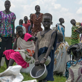 Mujeres y niños desplazados esperan una ración de comida proporcionada por el Programa Mundial de Alimentos. - AFP