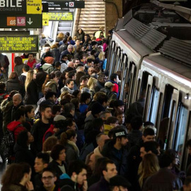 Usuarios del Metro de Barcelona esperan en el andén de la estación de Plaza España la llegada de un convoy. / QUIQUE GARCÍA (EFE)