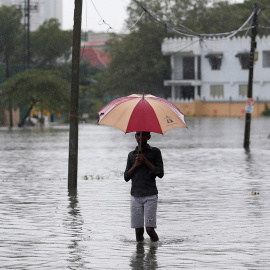 Un hombre sujeta un paraguas en una inundación en Colombo, Sri Lanka./ REUTERS