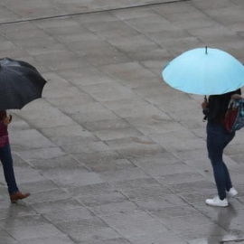 Escolares se protegen de la lluvia con paraguas en Bilbao / EFE