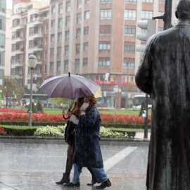 Varias personas se protegen de la fuerte lluvia en Bilbao. EFE/LUIS TEJIDO/Archivo