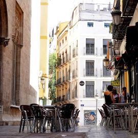 La terraza vacía de un bar frente al edificio de La Lonja, en el centro histórico de Valéncia. EFE/Manuel Bruque