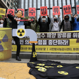 Un manifestante con una máscara que representa al primer ministro japonés simula la eliminación de agua radiactiva durante una manifestación para oponerse a la liberación de agua con materiales radiactivos de Fukushima.  -/YNA/dpa / Europa Press / Ar