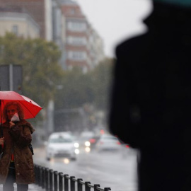 Dos transeúntes caminan entre la lluvia por las calles del centro de Madrid esta mañana de martes. EFE/ Mariscal