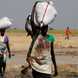 Varias mujeres llevan sacos de alimentos en el pueblo Nimini, en el estado de Unity, al norte de Sudán del Sur.- REUTERS / Siegfried Modola