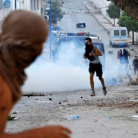 Manifestantes encapuchados lanzan piedras a la Policía antidisturbios durante la multitudinaria protesta en Alhucemas, Marruecos, el pasado 20 de julio.- REUTERS