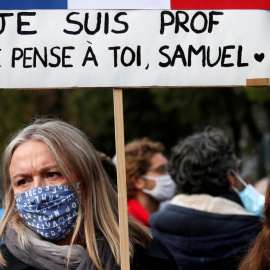 Una mujer sostiene una pancarta mientras asiste a un homenaje a Samuel Paty, el profesor de francés que fue decapitado en las calles del suburbio parisino de Conflans St Honorine, Francia. REUTERS / Pascal Rossignol / Archivo