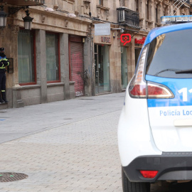 Un agente de la Policía Local de Salamanca vigila a las puertas de un local durante las labores de investigación de una "fiesta clandestina".