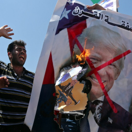 26/06/2019 - Palestinos queman una fotografía del presidente de EEUU, Donald Trump, como protesta contra la cumbre de Bahrein. / REUTERS - IBRAHEEM ABU MUSTAFA