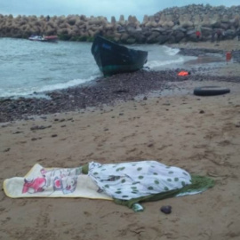 Imagen publicada por el portal 'le360.ma' en las que se ven varios cadáveres tapados con matas en una playa marroquí tras volar la patera con la que intentaban llegar a Canarias.