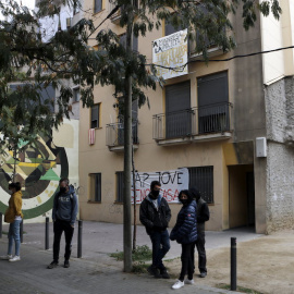 Diverses persones davant d'un bloc ocupat per joves a Manresa.