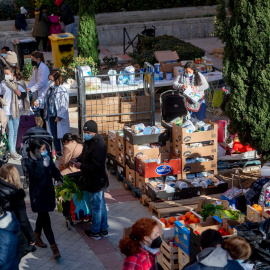 18/01/2022-Personas en riesgo de exclusión acuden a recoger alimentos, en la plaza de San Amaro, a 7 de enero de 2022, en Madrid (España).