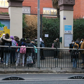 Pla general de l'Escola de les Aigües, amb pares i mares esperant alumnes.