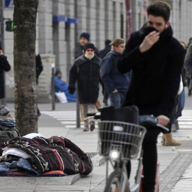 Una persona sin hogar dormita en la calle, en una imagen de archivo. AFP