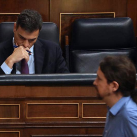 El líder de Podemos, Pablo Iglesias, pasa ante el jefe del Ejecutivo, Pedro Sánchez, durante el pleno del Congreso. (BALLESTEROS | EFE)