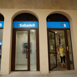 Una mujer sale de una sucursal del Banco Sabadell en Barcelona. REUTERS/ Albert Gea