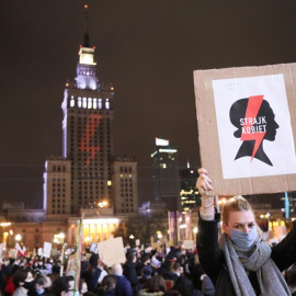 Una mujer sostiene una pancarta que dice 'Huelga de mujeres' mientras la gente participa en una protesta contra el endurecimiento de la ley de aborto en Varsovia, Polonia, el 30 de octubre de 2020.El Tribunal Constitucional de Polonia dictaminó el 22 de 