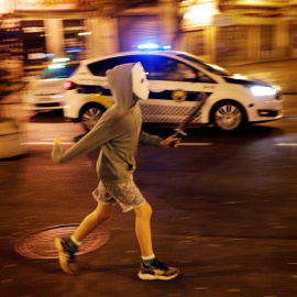 Un niño disfrazado corre por el centro de la ciudad durante esta noche en la que se celebra un Halloween "descafeinado", con toque de queda y mayor presencia policial.